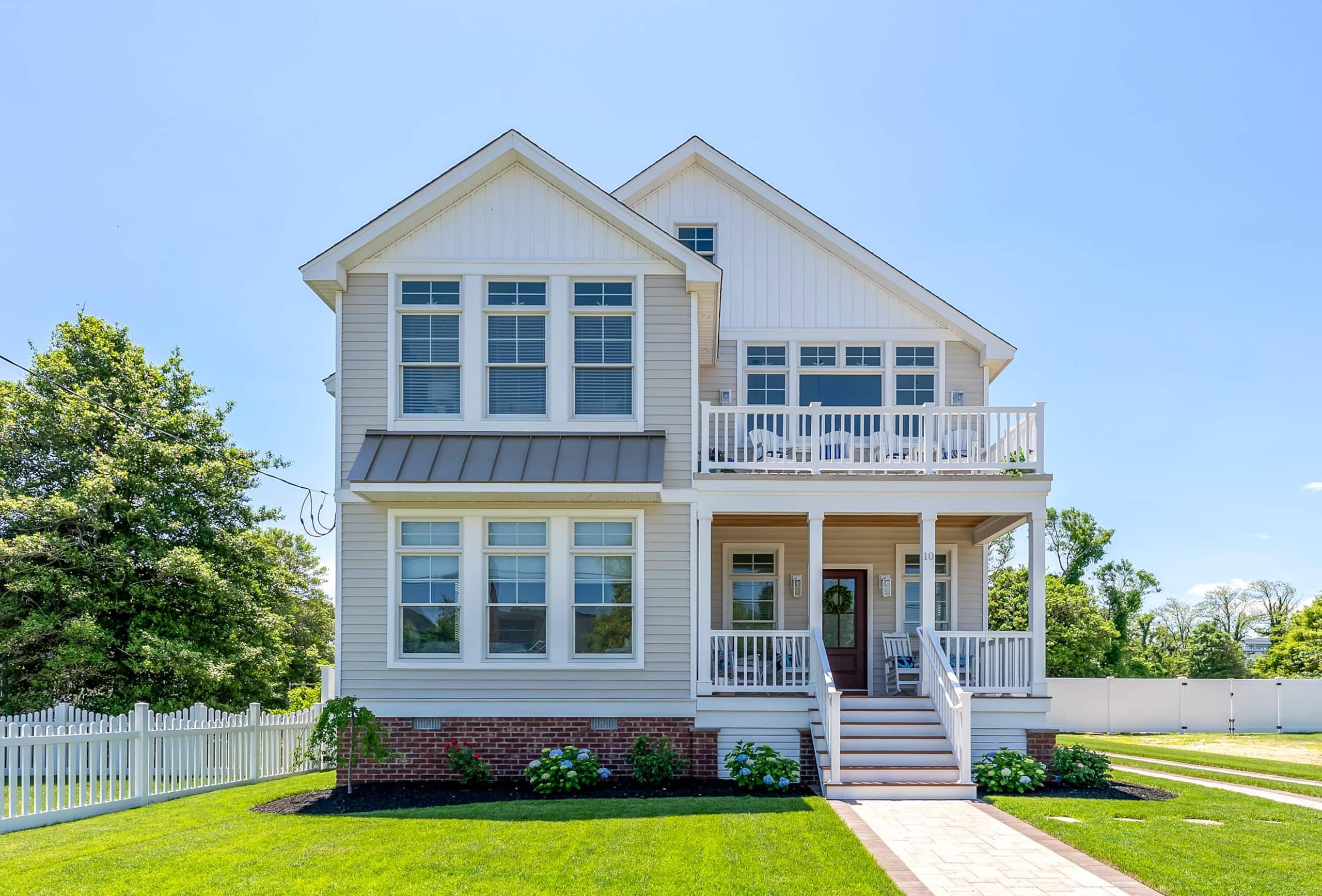 Street front of The Delford in North Cape May: light gray siding, a white porch, and a brick walk from the lawn
