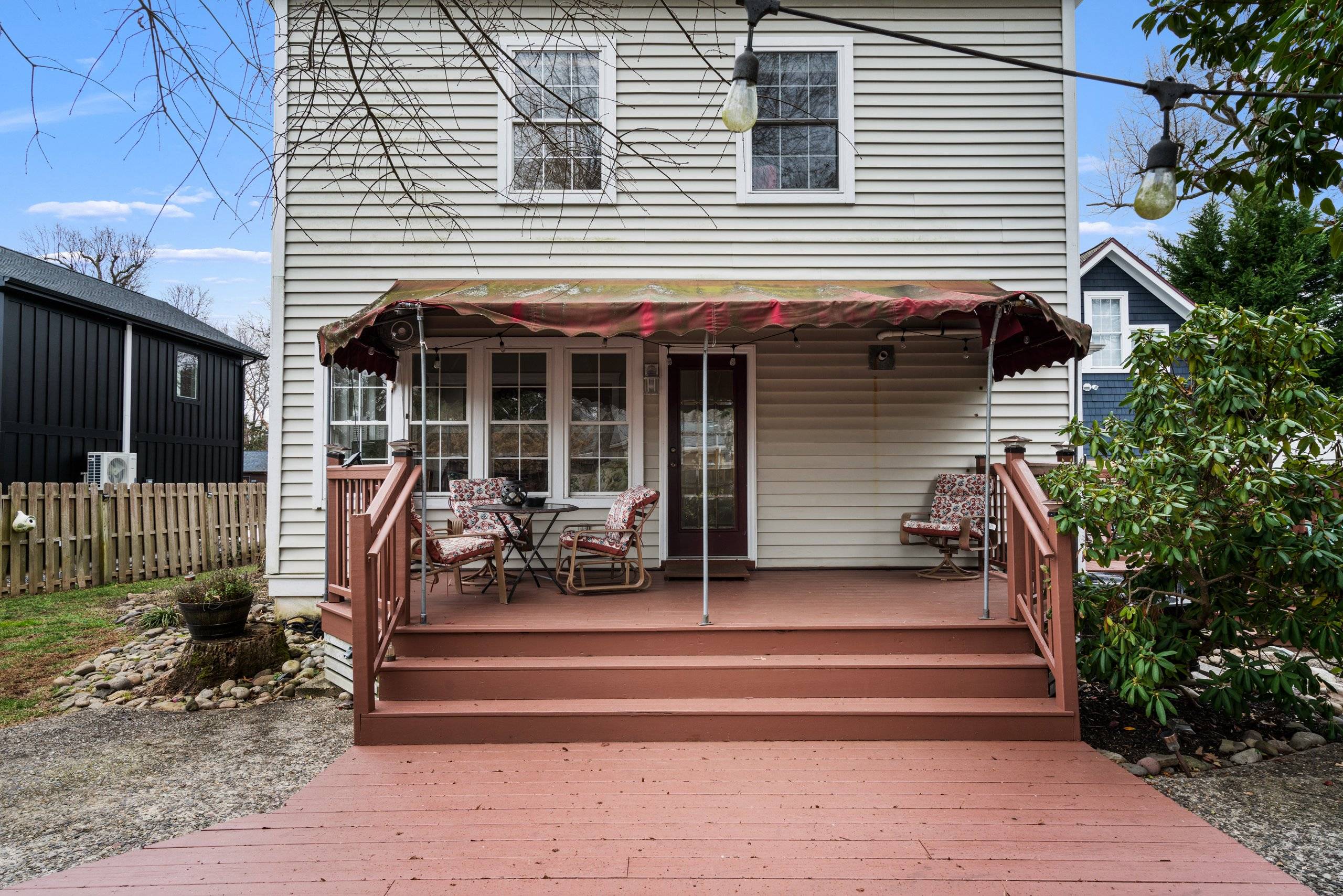 Back porch with string lights, steps to the deck